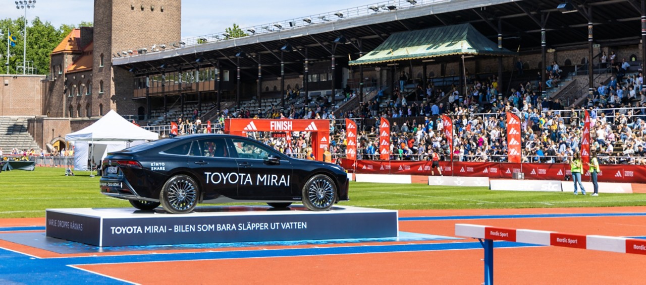 En svart Toyota Mirai står uppställd på ett podium på ett soligt Stockholms Stadion vid Stockholms Maratons målgång..